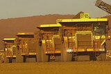 Fortescue trucks in a line at its Cloudbreak mine