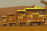 Fortescue trucks in a line at its Cloudbreak mine