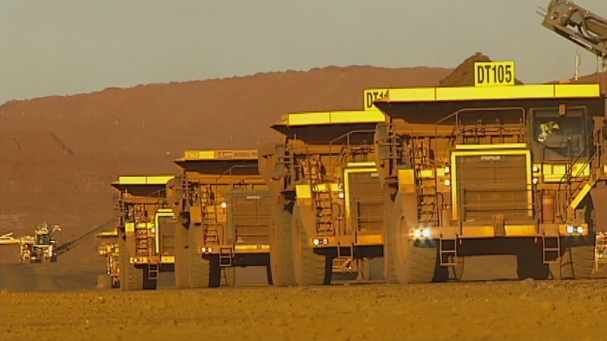 Fortescue trucks in a line at its Cloudbreak mine