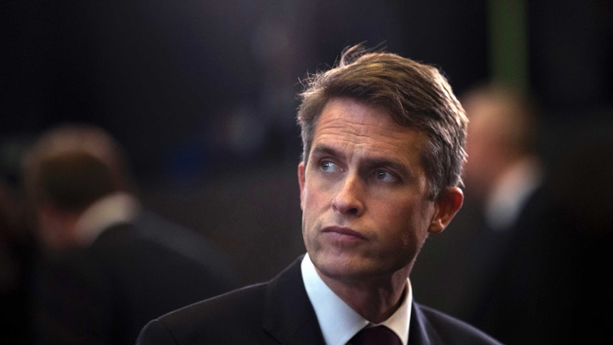 Former British defence secretary Gavin Williamson stands during a NATO gathering.