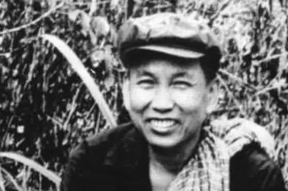 Black and white photo shows a smiling Pol Pot.