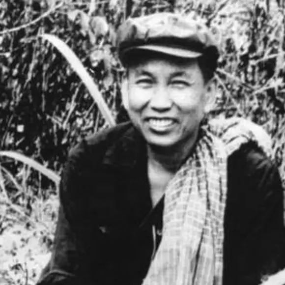 Black and white photo shows a smiling Pol Pot.
