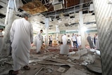 Saudi men gather around debris inside mosque