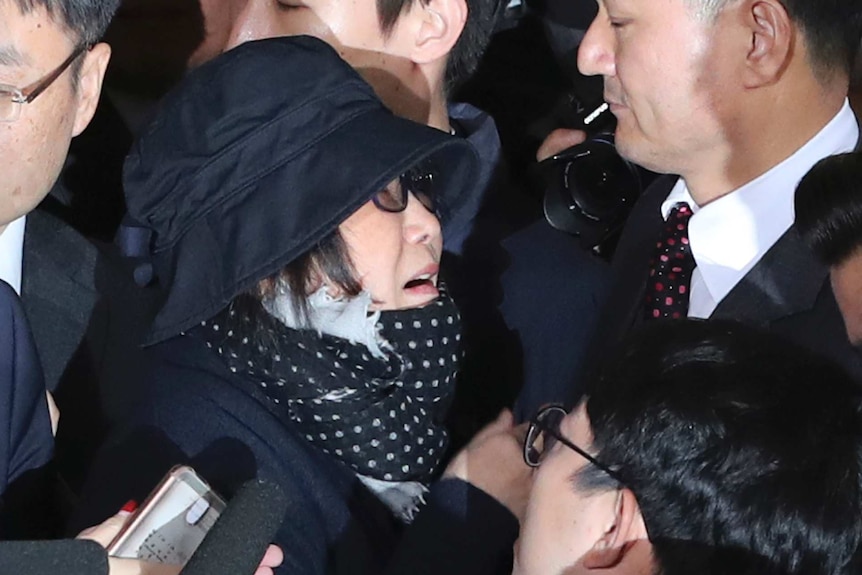 Choi Soon-sil, centre left, is surrounded by officers and media upon her arrival at the prosecutors office in Seoul.