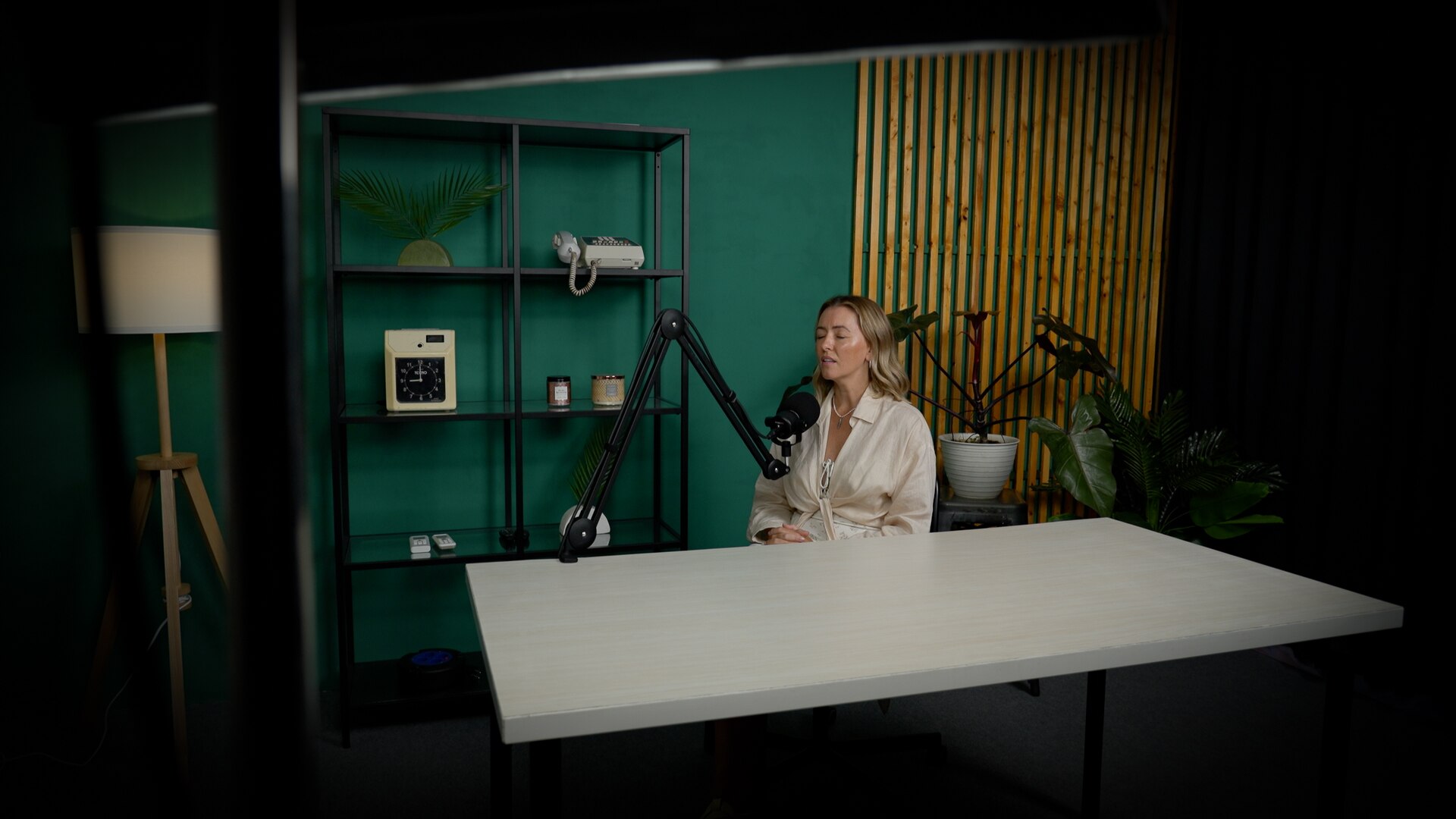 A blonde woman sits in a recording studio with her eyes closed 
