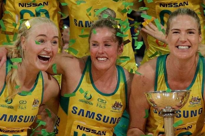 Australia's Diamonds celebrate with the Constellation Cup as confetti falls on them.