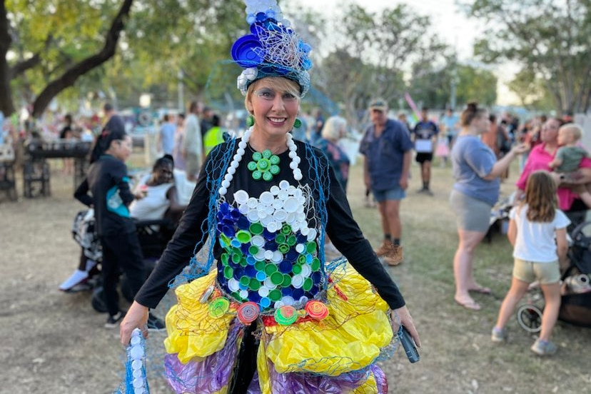 a blonde woman wearing a dress made from bottle caps and wire