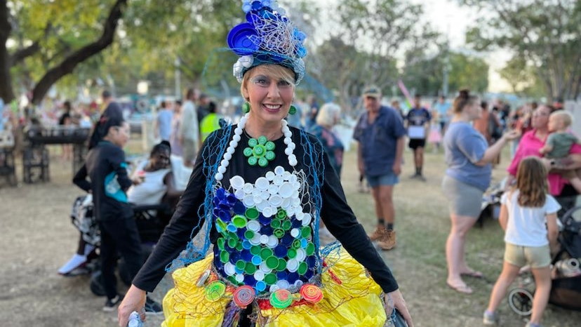 a blonde woman wearing a dress made from bottle caps and wire