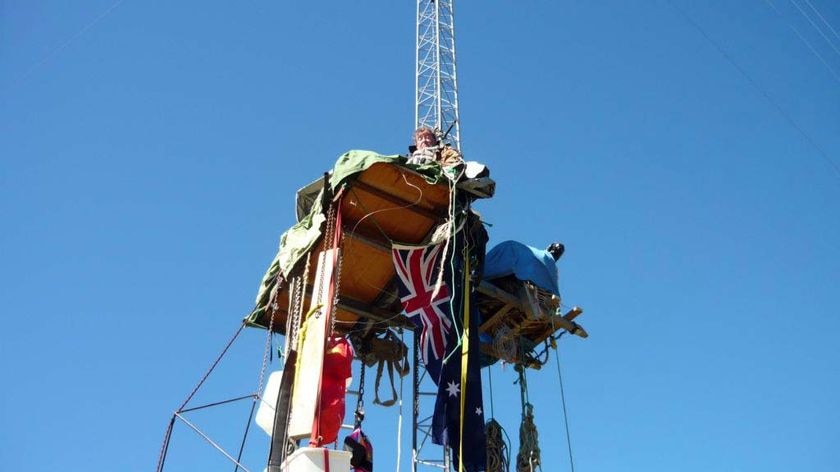 Grazier Peter Spencer sits chained to a wind mast 18 metres above the ground