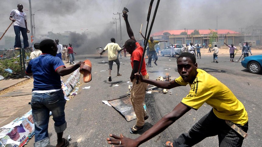 People holding wooden and metal sticks demonstrate in Nigeria's northern city of Kano. (AFP)