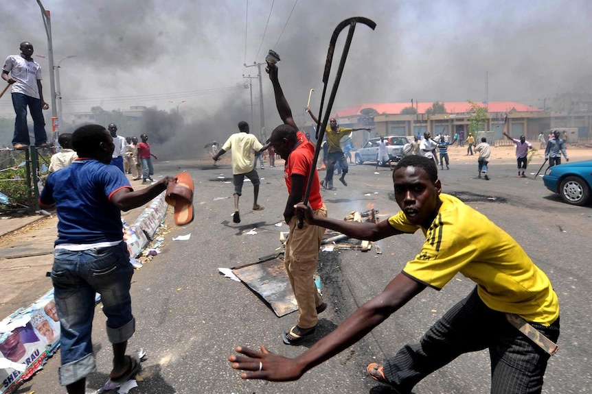 People holding wooden and metal sticks demonstrate in Nigeria's northern city of Kano. (AFP)