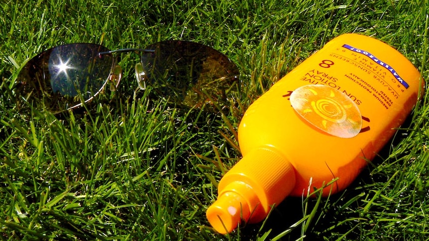Close-up of sunscreen bottle and sunglasses on the grass, April 2012.