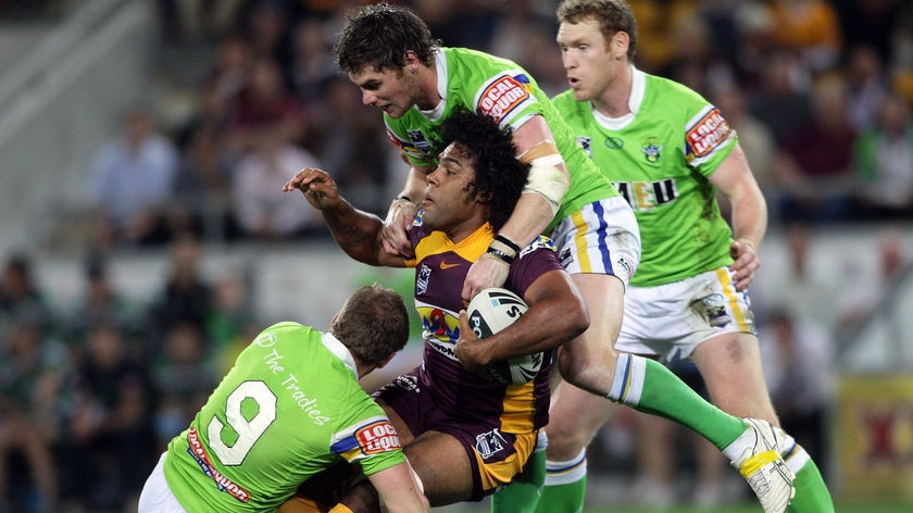 Wrapped up: The Raiders set in on powerful Broncos forward Sam Thaiday.