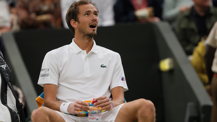 Daniil Medvedev sits at Wimbledon with a pained expression on his face.