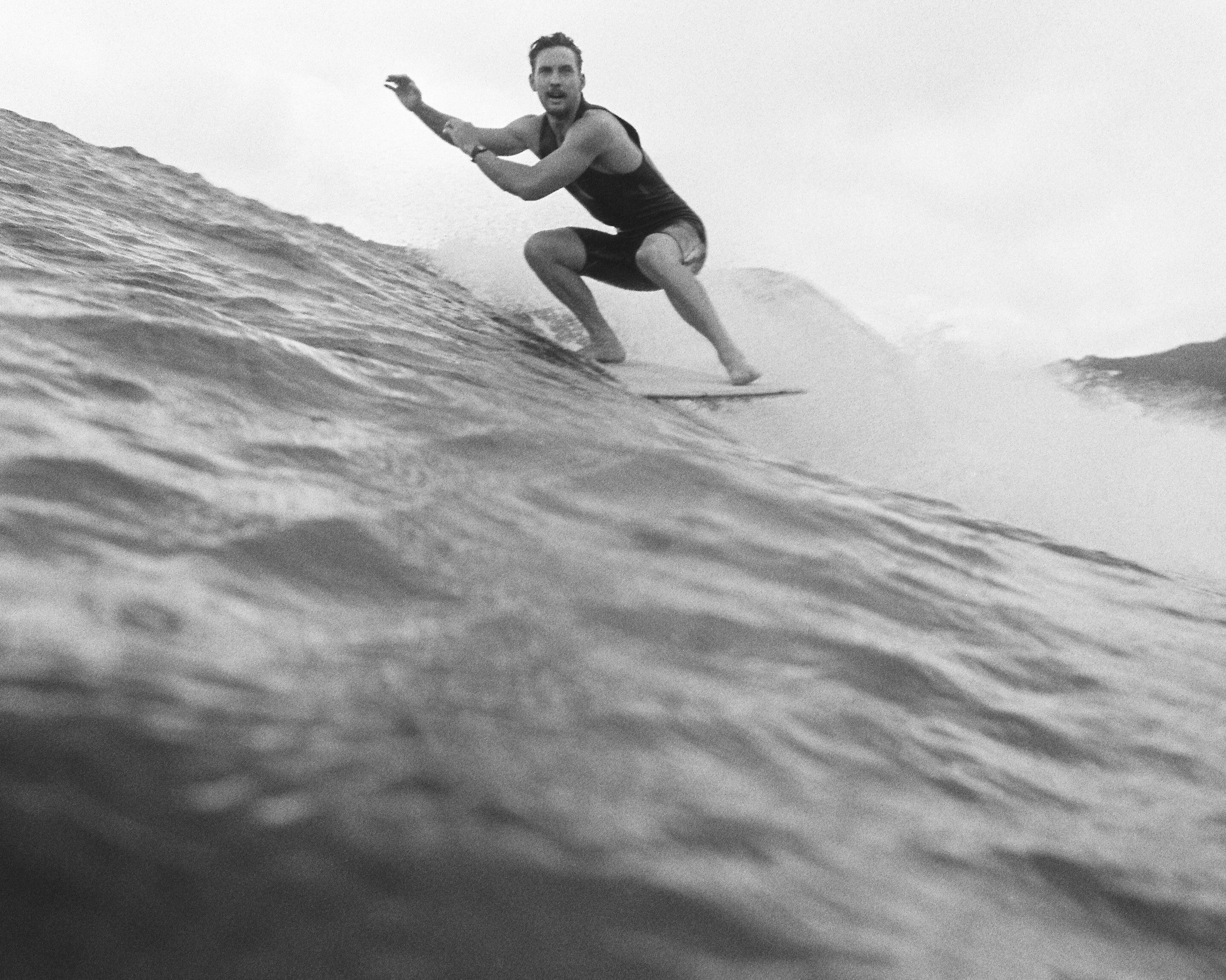 A black and white image of a surfer on a wave