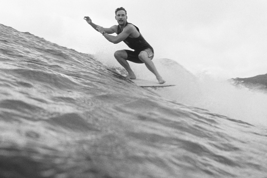 A black and white image of a surfer on a wave