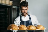 Pastry chef Will Jane inspects four sourdough loaves in his kitchen.