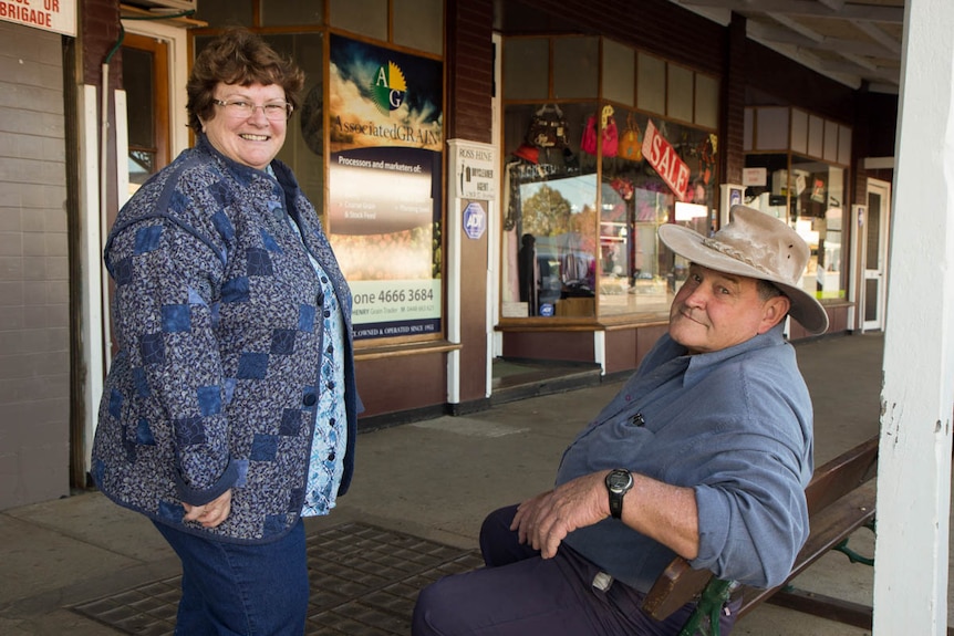 Sister Christine speaking a man siting on a street bench.