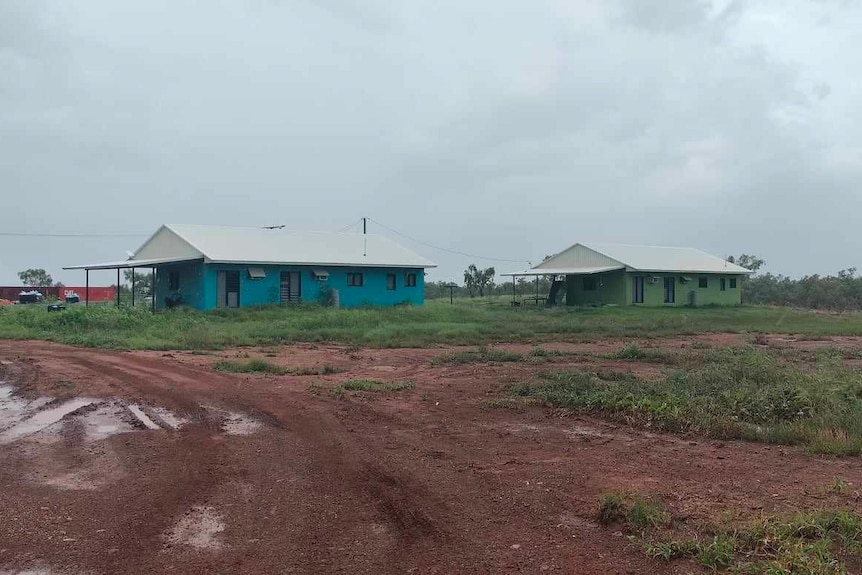 two one-storey houses in a muddy remote community