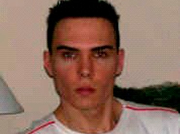 A grainy picture of Luka Magnotta staring unsmiling at the camera.