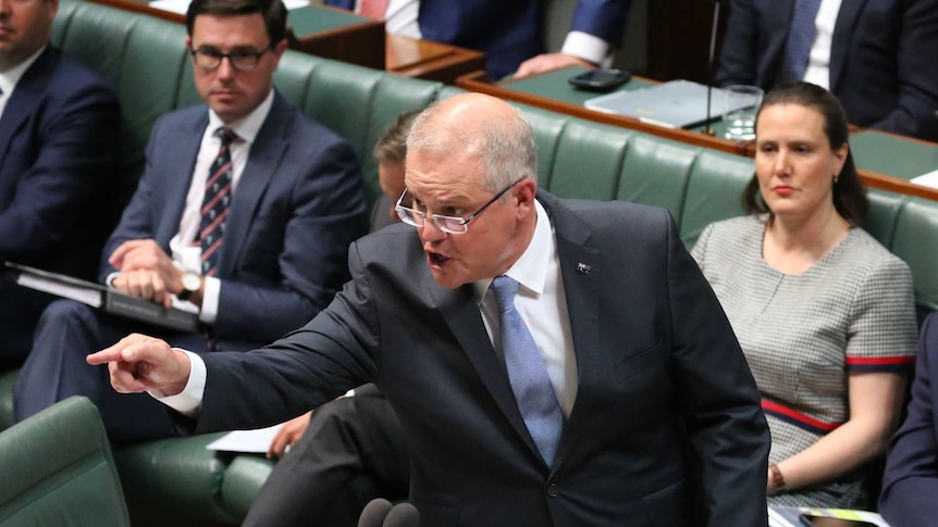 A man talking points across the room as he looks angrily across the House of Representatives