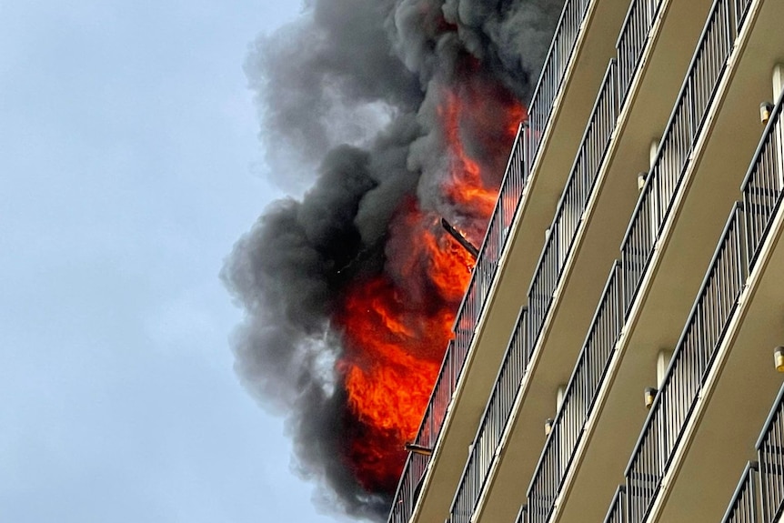 Flames leap from a hotel balcony