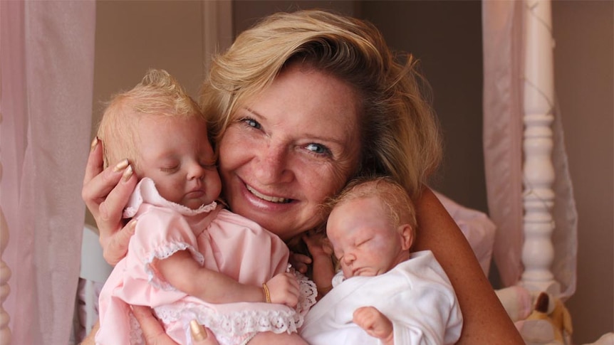 Vynette Smith and two of the reborn dolls she has made.
