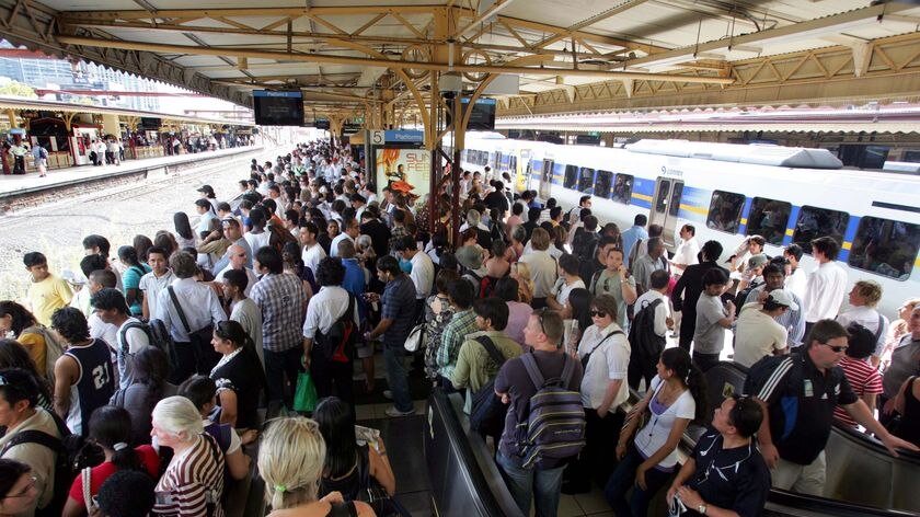 Rail commuters crowd onto a platform on Flinders Street Station in Melbourne