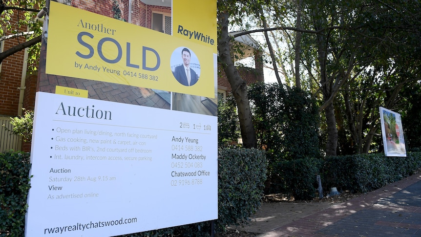 A real estate agent sign outside a house