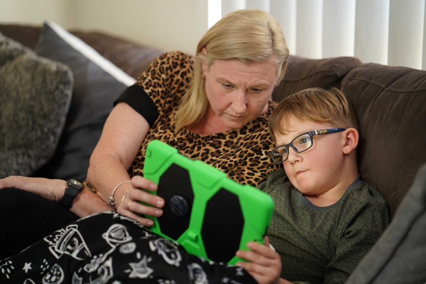 Ipswich mother Megan Wagstaff sits on the couch with her son Wilson doing home-schooling.