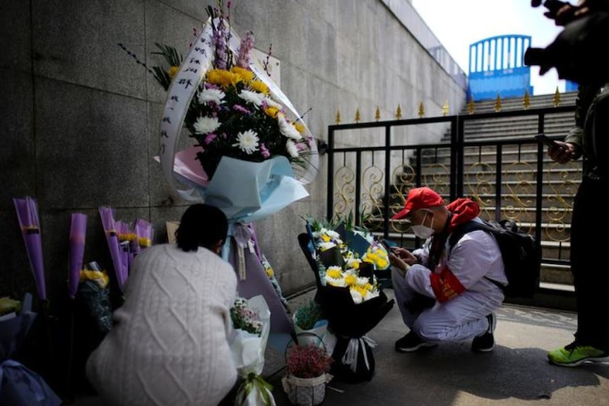 People lay flowers to remember the dead.