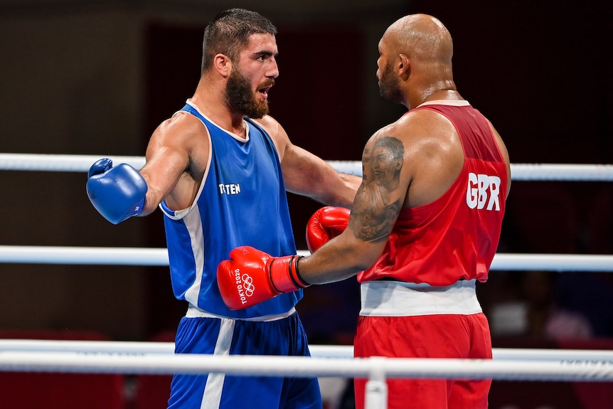 A French male boxer reacts as he stands in front of his British opponent.