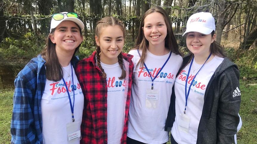 Four girls smile at the camera.