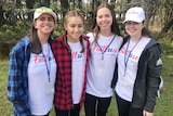 Four girls smile at the camera.