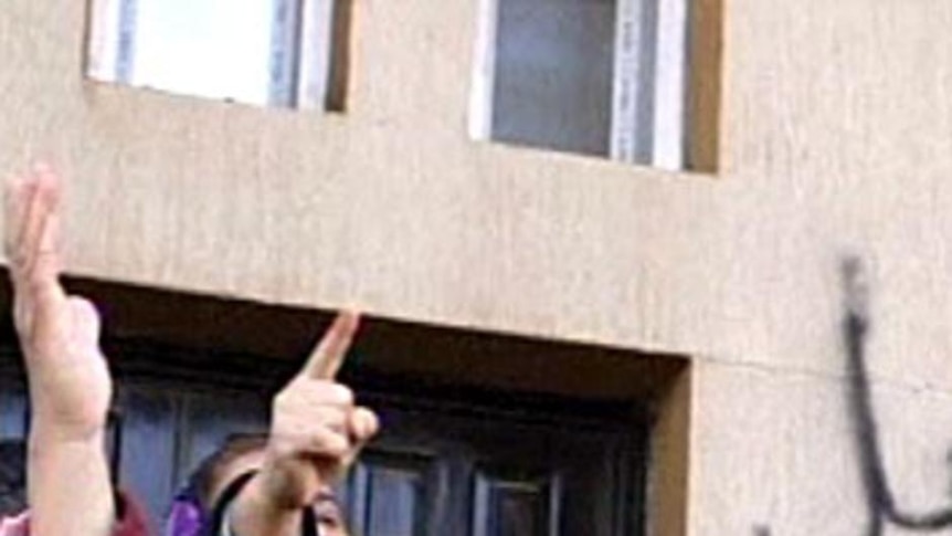 A woman gestures skyward during anti-government protests in the Libyan city of Benghazi