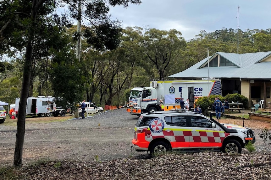 Emergency vehicles outside a building in a bushy location