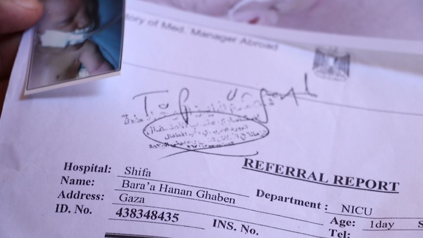 A referral report with a photo of a week-old baby attached has the words "top urgent" written in black pen across the top.