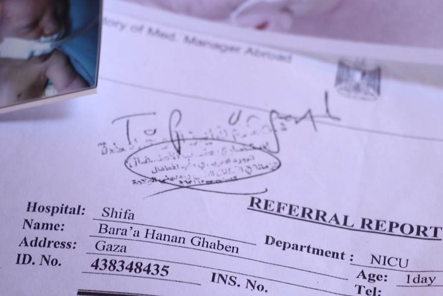 A referral report with a photo of a week-old baby attached has the words "top urgent" written in black pen across the top.