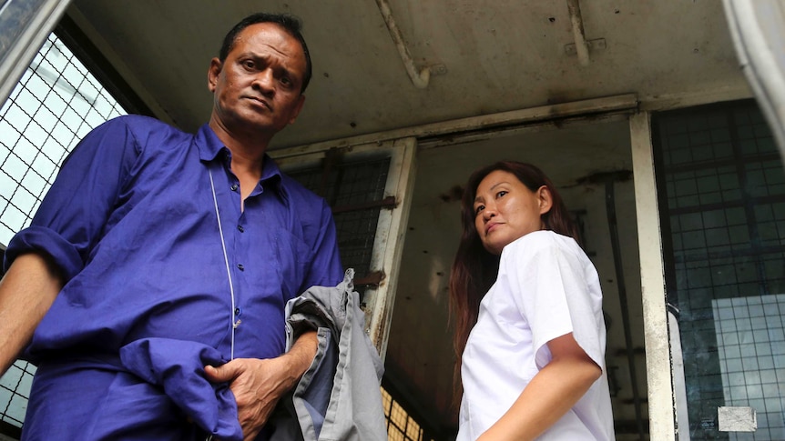 Malaysian journalist Mok Choy Lin, right, and Myanmar driver Hla Tin leaves after their trial at a Myanmar court.