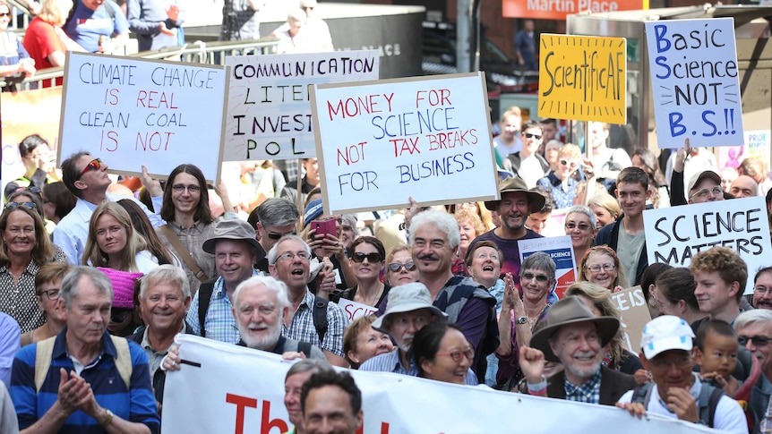 A sea of protesters holding signs stand in martin place on science day
