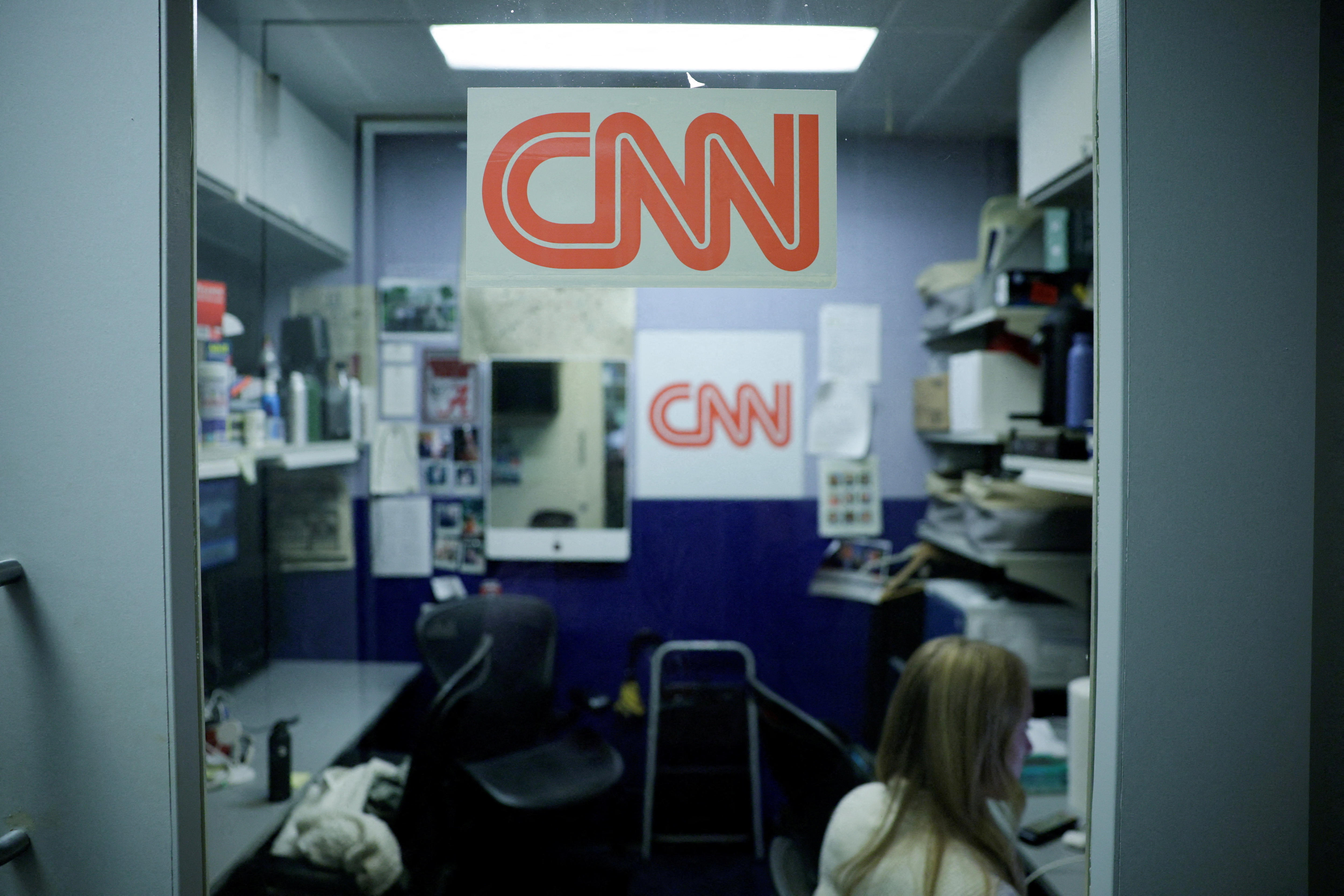 一个空的 CNN 展位、办公桌和办公设备。