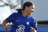 Chelsea's Sam Kerr jogs away with a smile as Leicester's goalkeeper is slumped on the ground.