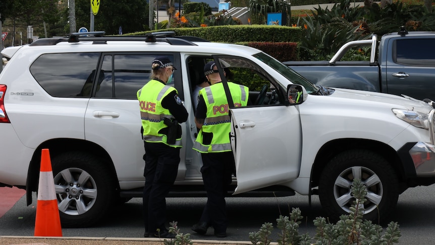 Police officers talk to drivers at NSW-Queensland border patrol