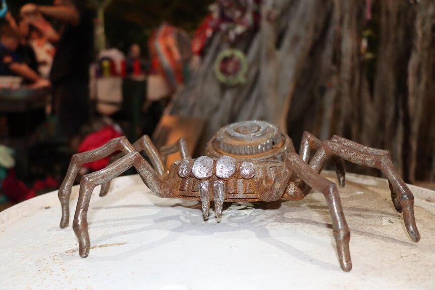 A spider sculpture made out of rusted metal. 