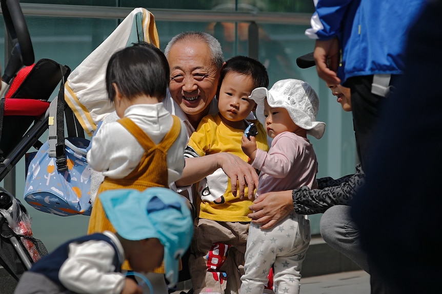 一位抱着孩子的中国爷爷