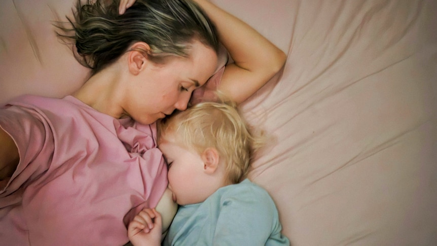 Kellie and Lane in bed together breastfeeding