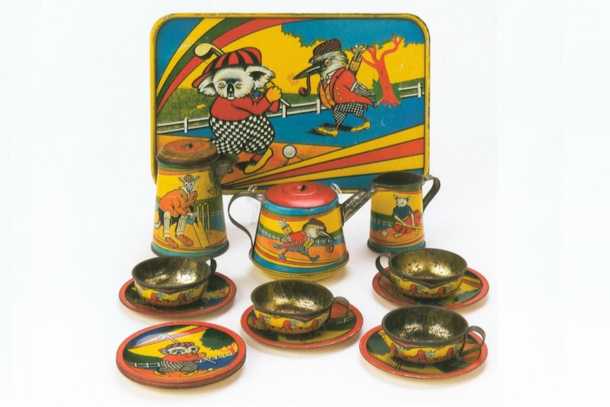 A vintage toy tea set including a tray, kettle, teapot, cups and saucers, illustrated with Australian animals in garish colours