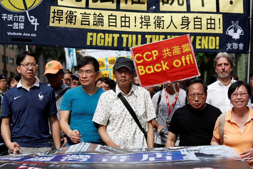 Lam Wing-kee (C) takes part in a protest march with pro-democracy lawmakers and supporters.