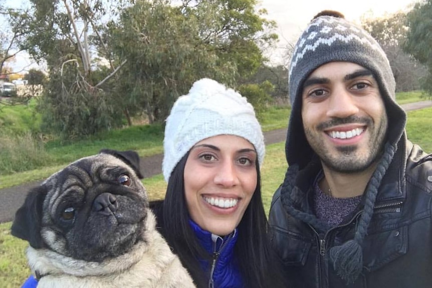 Pamela Bousejean stands in a park with her brother James and pug dog Percy.