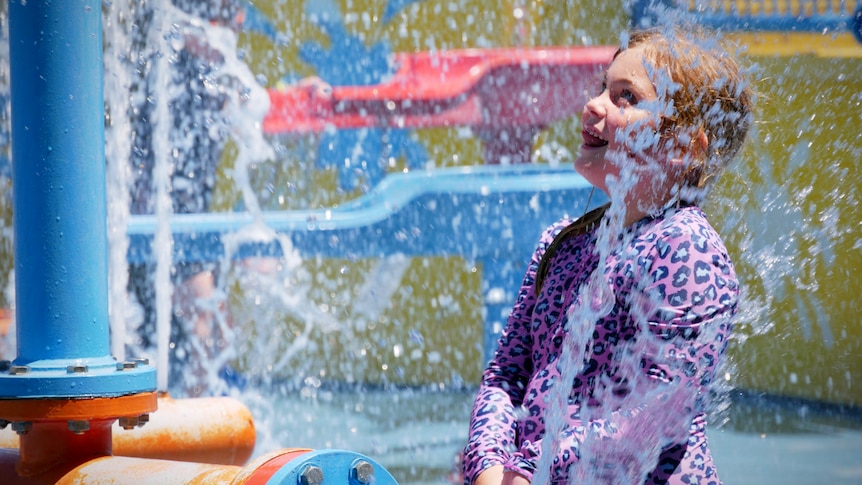 A young girl plays at a water park 